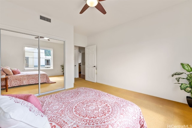 bedroom with visible vents, a closet, ceiling fan, and carpet flooring