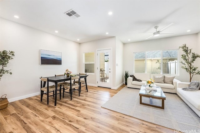 living room featuring baseboards, light wood finished floors, visible vents, and recessed lighting