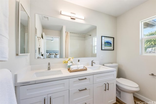 ensuite bathroom with ensuite bathroom, toilet, a sink, and visible vents