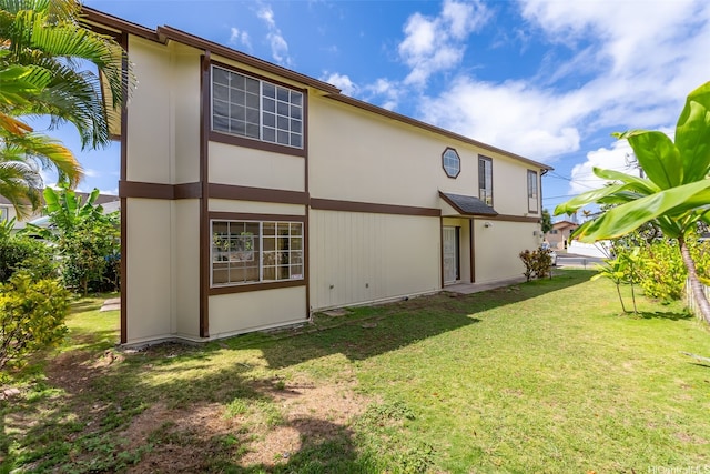 back of property featuring a lawn