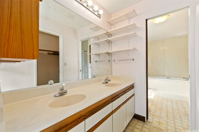bathroom with double vanity, a tub to relax in, and tile patterned floors