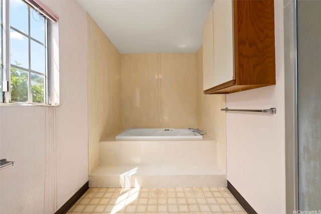 full bathroom featuring a bath, baseboards, and tile patterned floors