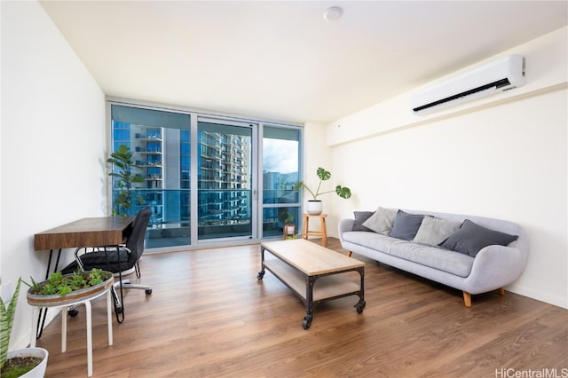 living area with an AC wall unit, a wall of windows, wood finished floors, and baseboards