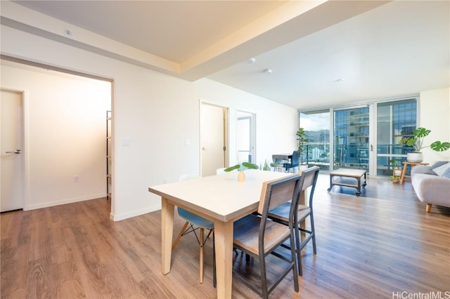 dining area featuring floor to ceiling windows, baseboards, and wood finished floors