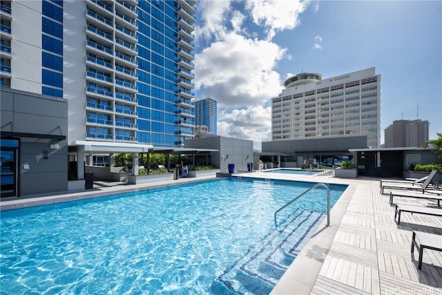 community pool with a patio area and a city view