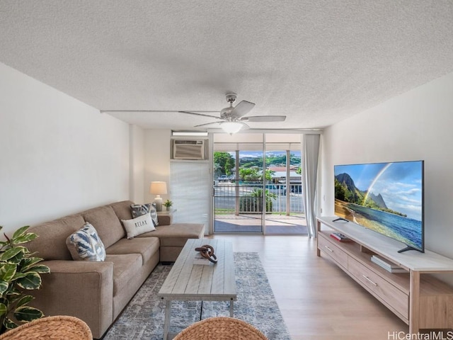 living room featuring floor to ceiling windows, a wall unit AC, ceiling fan, a textured ceiling, and light wood-type flooring