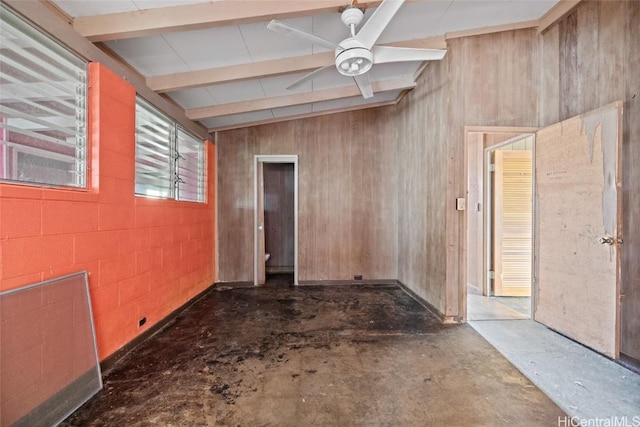 unfurnished room featuring ceiling fan, beam ceiling, unfinished concrete flooring, and concrete block wall