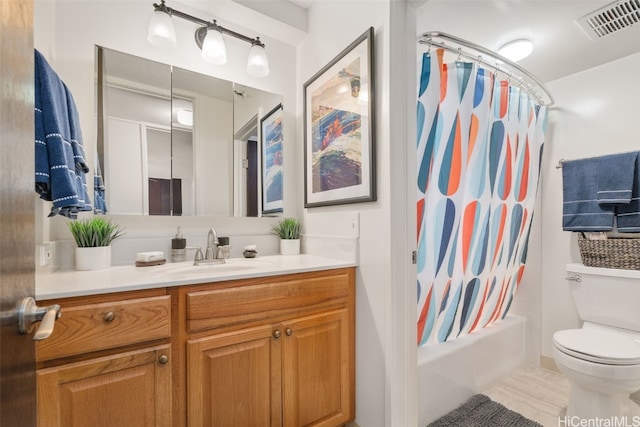 bathroom featuring visible vents, vanity, toilet, and shower / bath combo with shower curtain