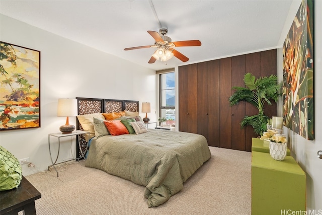 bedroom featuring light carpet, ceiling fan, and wooden walls