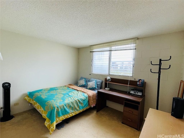 bedroom featuring a textured ceiling, carpet, and concrete block wall