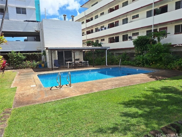 view of pool featuring a lawn