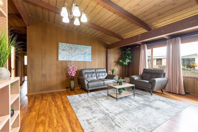 living area with lofted ceiling with beams, wooden ceiling, wood finished floors, and an inviting chandelier