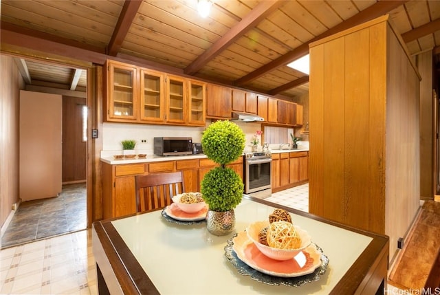 kitchen with light countertops, appliances with stainless steel finishes, and brown cabinetry