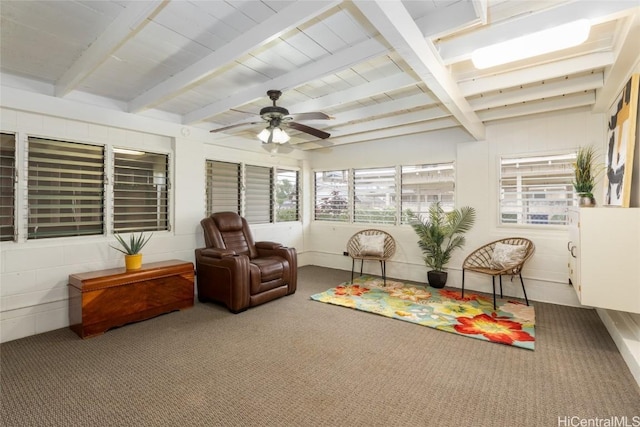 sunroom / solarium with a ceiling fan and beam ceiling