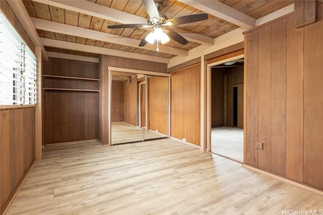 unfurnished bedroom featuring ceiling fan, light wood-style flooring, wooden walls, wood ceiling, and beam ceiling