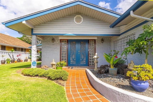 entrance to property featuring a lawn and fence