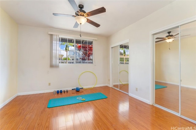 workout area featuring ceiling fan, baseboards, and wood finished floors