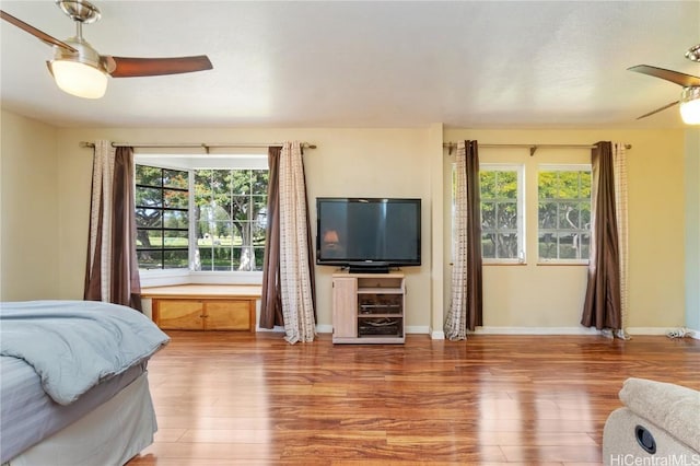 bedroom featuring ceiling fan, wood finished floors, and baseboards