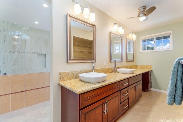 full bathroom featuring a ceiling fan, a sink, a tile shower, and double vanity