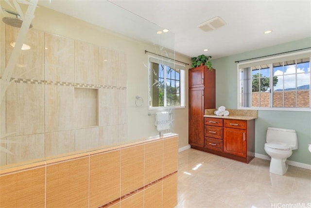 full bathroom with visible vents, baseboards, tiled shower, toilet, and vanity