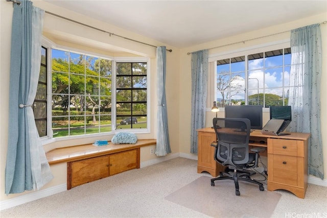 home office featuring plenty of natural light, baseboards, and light colored carpet