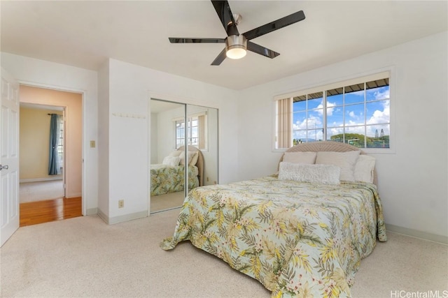 bedroom with a ceiling fan, carpet, baseboards, and a closet