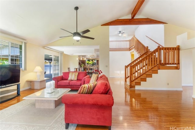 living area featuring baseboards, wood finished floors, stairs, beam ceiling, and ceiling fan with notable chandelier