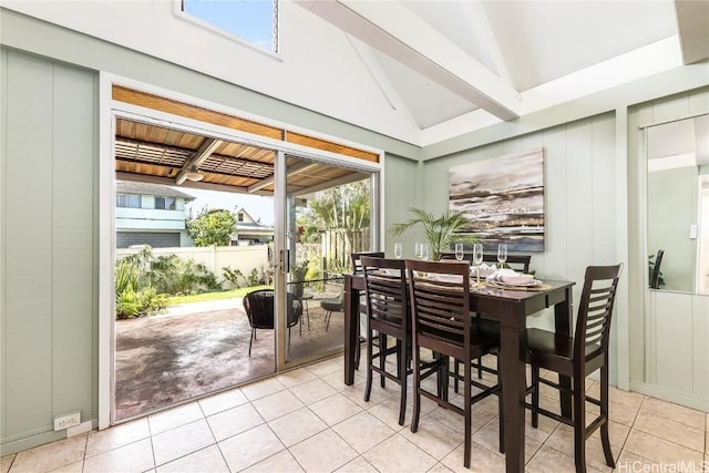 dining space featuring light tile patterned flooring and vaulted ceiling