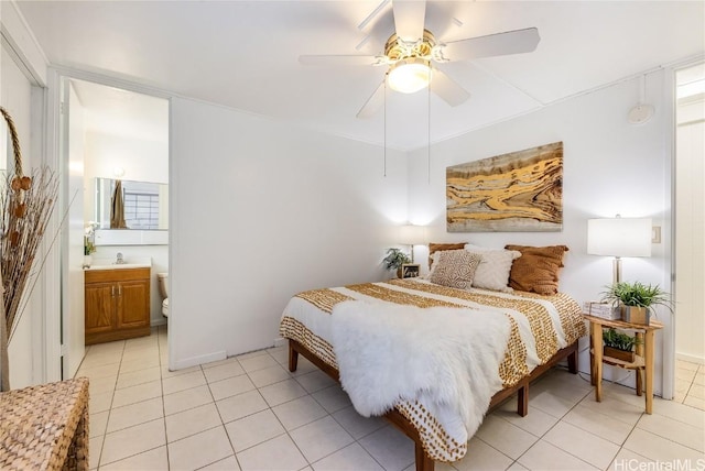 bedroom featuring light tile patterned floors, ceiling fan, a sink, and ensuite bathroom