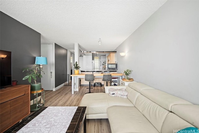 living room with a textured ceiling and wood finished floors