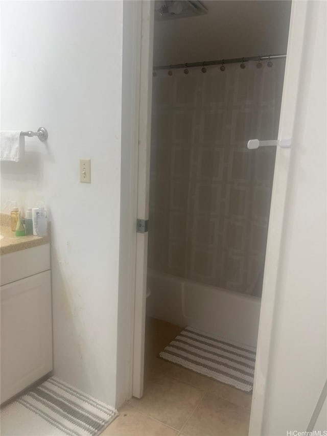 bathroom with tile patterned floors, shower / bathtub combination with curtain, and vanity