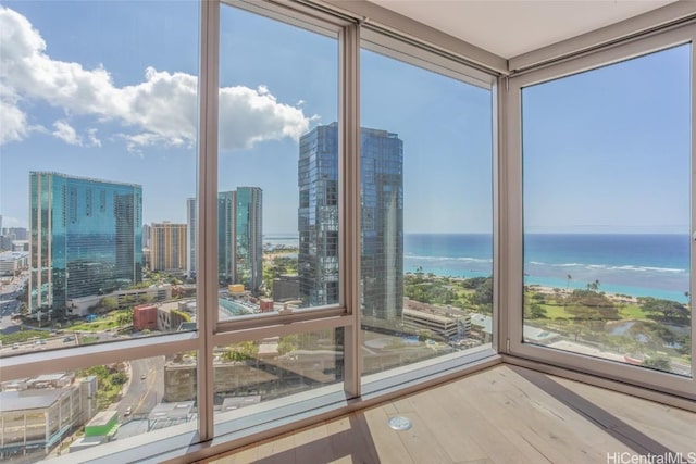 unfurnished sunroom featuring a water view and a city view