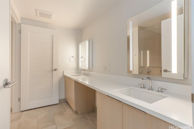 bathroom featuring double vanity, a sink, visible vents, and tile patterned floors