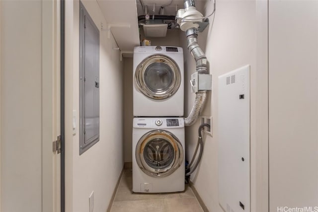 laundry room with light tile patterned floors, laundry area, and stacked washer and clothes dryer