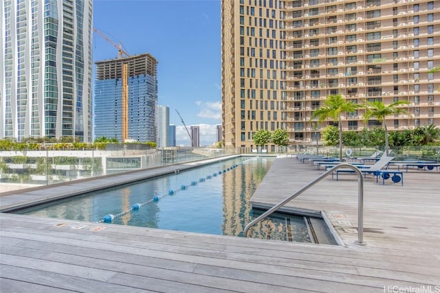 view of swimming pool featuring a water view and a city view