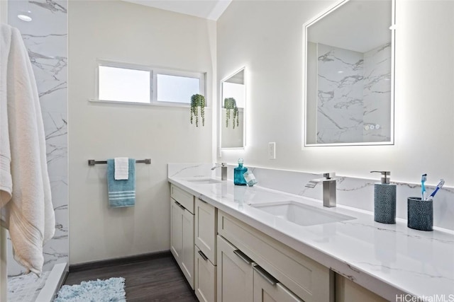 full bath featuring double vanity, a sink, and wood finished floors