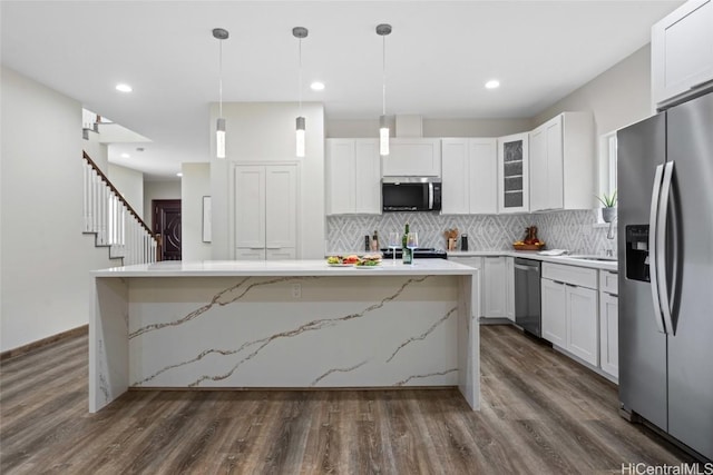 kitchen featuring appliances with stainless steel finishes, white cabinets, and a center island