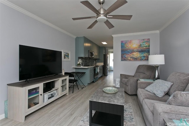 living room with light wood-style flooring, baseboards, ceiling fan, and crown molding