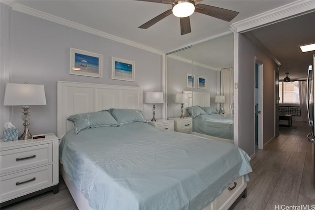 bedroom featuring a ceiling fan, a closet, crown molding, and wood finished floors