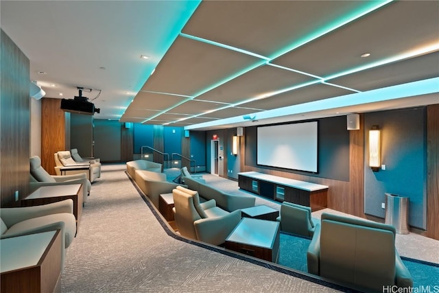 carpeted cinema room featuring wooden walls