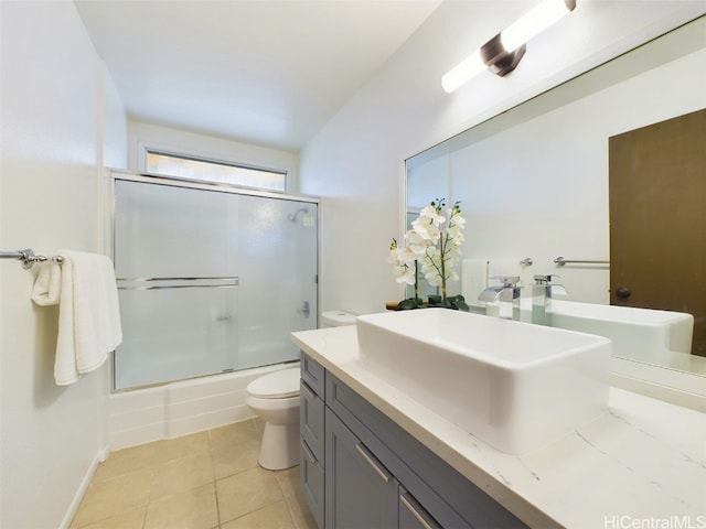 full bath with shower / bath combination with glass door, vanity, toilet, and tile patterned floors