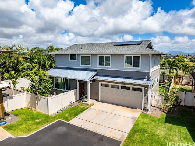 traditional home with fence private yard, concrete driveway, solar panels, and a front yard