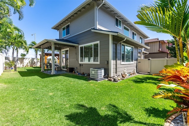 rear view of house with a patio area, central AC, fence, and a lawn