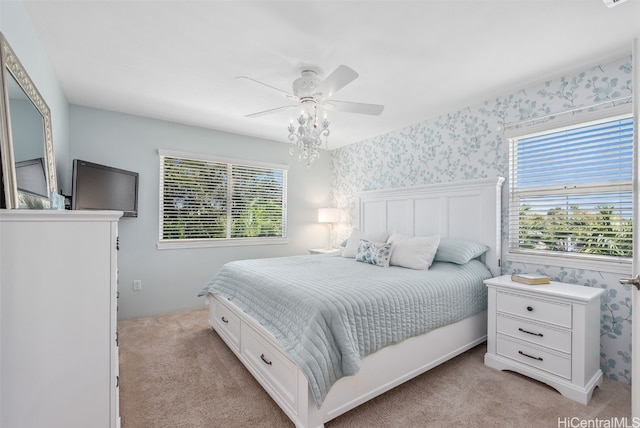 bedroom featuring light colored carpet, ceiling fan, and wallpapered walls