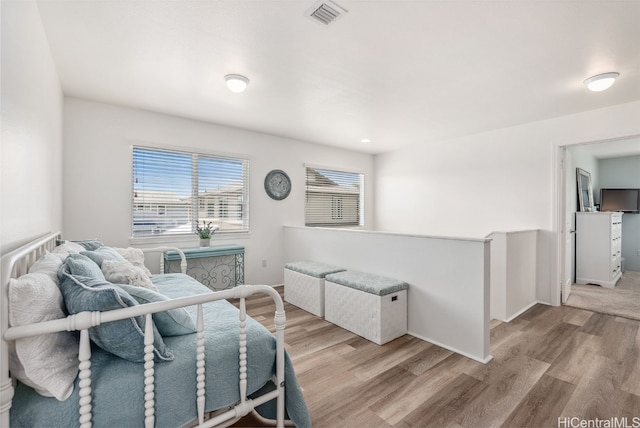 bedroom featuring light wood-style flooring, visible vents, and baseboards