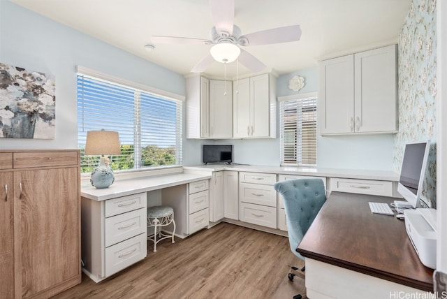 office area featuring light wood-style floors, built in study area, and ceiling fan