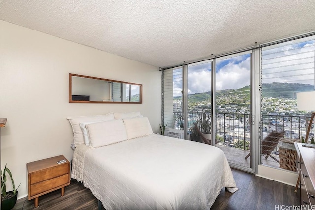 2121 Algaroba St Unit 1602, Honolulu, HI 96826 - bedroom featuring access to exterior, expansive windows, dark wood finished floors, and a textured ceiling