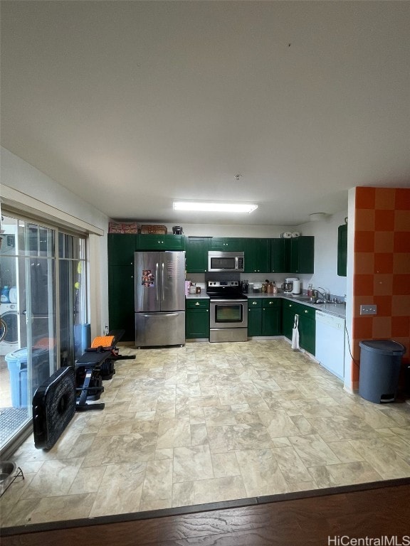 kitchen featuring stainless steel appliances, light countertops, a sink, and green cabinets