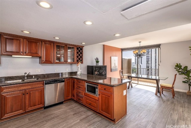 311 Ohua Ave Unit Ph D, Honolulu, HI 96815 - kitchen featuring brown cabinets, appliances with stainless steel finishes, a peninsula, wood finished floors, and a sink