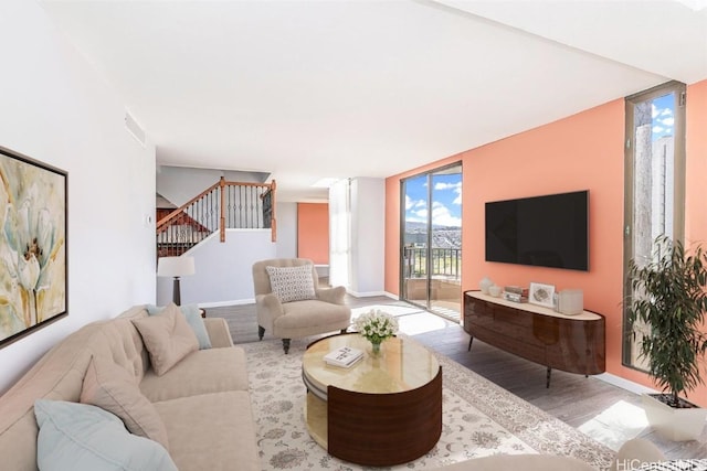 311 Ohua Ave Unit Ph D, Honolulu, HI 96815 - living room with visible vents, wood finished floors, a wall of windows, baseboards, and stairs